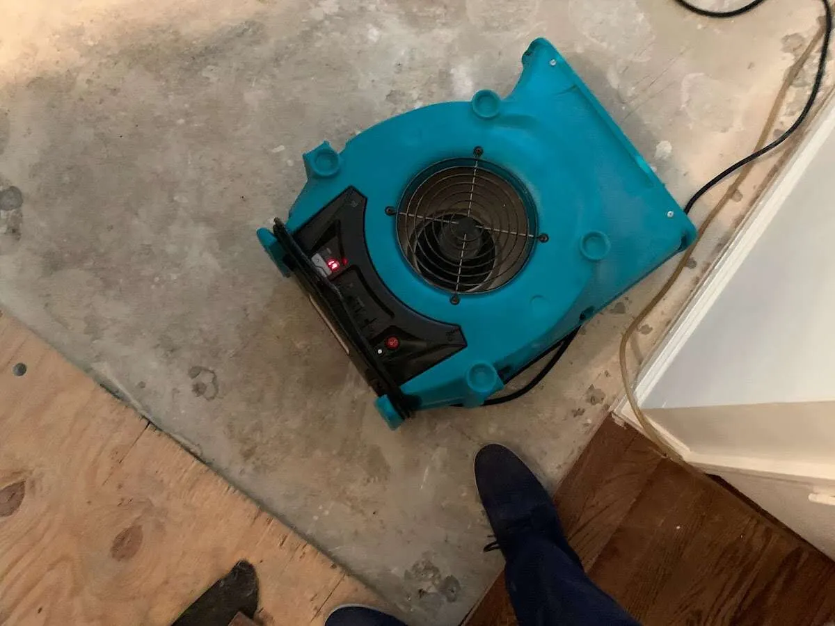 Air mover drying subfloor during Commercial Water Damage Restoration in Versailles